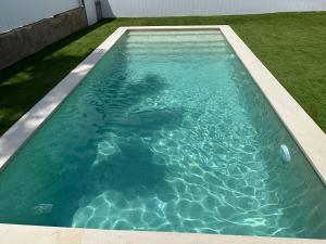 a swimming pool with blue water in a yard at Myhost Augusta Altafulla in Altafulla