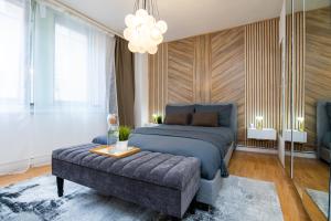 a bedroom with a bed and a couch and a chandelier at Charming GEM II 2BD 2BA Retreat in London