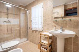 a bathroom with a sink and a toilet and a shower at MyHouseSpain - Único piso cerca de la playa in Gijón