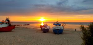 a group of boats on the beach at sunset at UniBal - pokoje gościnne in Unieście