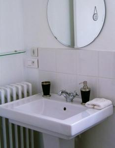 lavabo blanco en el baño con espejo en La Villa Camille, en La Creche