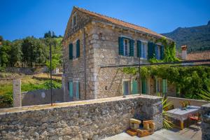 ein Steinhaus mit Kamin davor in der Unterkunft Authentic house and traditional breakfast in Vrisnik