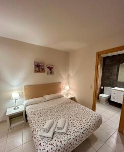 トッサ・デ・マールにあるApartamentos TDMのベッドルーム1室(ベッド1台、タオル2枚付)