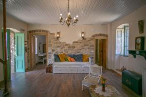 a living room with a couch and a stone wall at Authentic house and traditional breakfast in Vrisnik