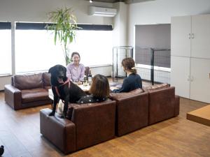 Un gruppo di persone sedute su un divano con un cane di Tiz wan hotel a Sumoto