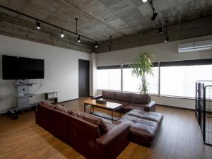 a living room with leather couches and a flat screen tv at Tiz wan hotel in Sumoto