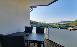 una mesa y sillas en un balcón con vistas en Ferienwohnung Windhagen, en Windhagen