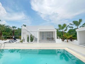 a swimming pool in front of a house at ทิพย์วาริน รีสอร์ท เขาใหญ่ in Ban Tha Chang