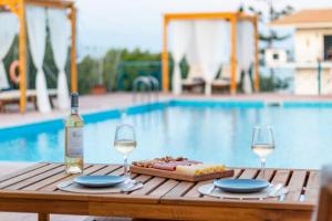 a table with a bottle of wine and two glasses at Koroni Xenios Zeus, Seaview Summer Retreats in Koroni