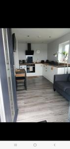 a living room with a couch and a kitchen at Self catering. Maydene. Holm. Orkney, Scotland. in Nether Button