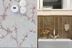 a bathroom with a sink and flowers on the wall at Willa Szwarc by Elite Apartments in Sopot +127 photos