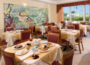 a restaurant with tables and chairs with food on them at Hotel Belvedere in Misano Adriatico