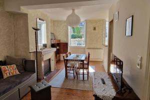 a living room with a table and a dining room at Spacieuse Maison de ville - Quartier Calme - 10 Personnes in Oloron-Sainte-Marie