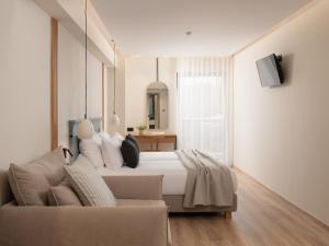een slaapkamer met een bed en een bank bij Hotel Ideon in Rethimnon