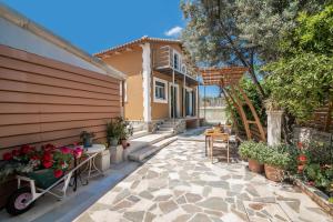 a patio with a table and flowers and a house at Zamor Family Villa 2 in Zakynthos Town