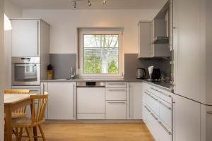 a kitchen with white cabinets and a table and a window at Ferienhaus Lienz in Lienz