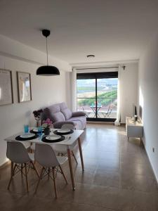 een woonkamer met een tafel en een bank bij Apartamento Margalló con Garaje in Xilxes