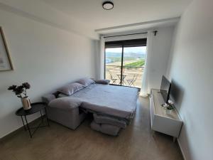een kamer met een bed, een bank en een raam bij Apartamento Margalló con Garaje in Xilxes