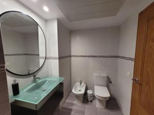 een badkamer met een wastafel, een toilet en een spiegel bij Apartamento Margalló con Garaje in Xilxes +20 foto's