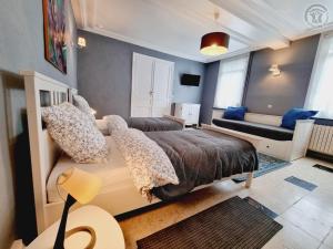 ein Schlafzimmer mit einem großen Bett und einem Sofa in der Unterkunft La ferme bisiaux in Somain