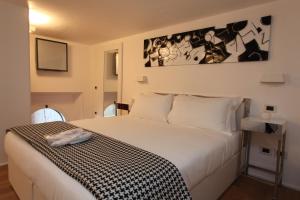 una camera da letto con un letto con una coperta bianca e nera di LHP Suite Roma Piazza del Popolo a Roma