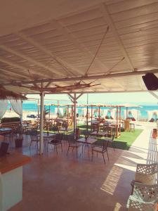 a patio with tables and chairs and the beach at Larissa in Skala