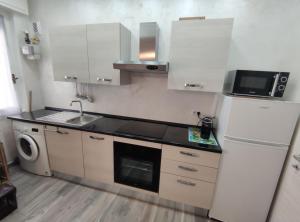 a kitchen with a white refrigerator and a microwave at CASA DADO in Rapallo