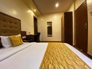 a bedroom with a large white bed with a yellow pillow at Hotel Pearl's BKC Inn- Near Trade Centre, Visa Consulate in Mumbai