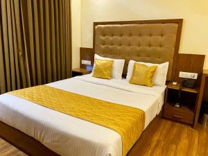 a hotel room with a large bed with yellow pillows at Hotel Pearl's BKC Inn- Near Trade Centre, Visa Consulate in Mumbai