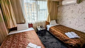 um quarto de hotel com duas camas e uma janela em Select Inn Shimada Ekimae em Shimada