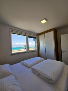 2 łóżka w sypialni z widokiem na plażę w obiekcie Apartmani Adria w Nin