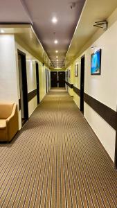 un corridoio vuoto in un edificio per uffici con divano di Hotel Pearl's BKC Inn- Near Trade Centre, Visa Consulate a Mumbai