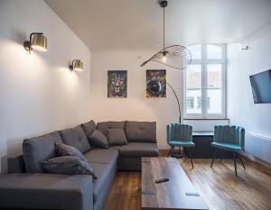 ein Wohnzimmer mit Sofa und Tisch in der Unterkunft Le Logis de l'Arc - 5min Hypercentre - Max 6 Personnes in Troyes
