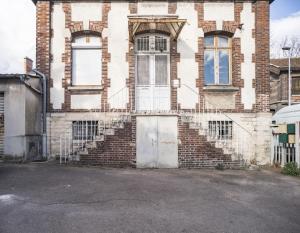 un vecchio edificio in mattoni con porta e scale di Le Logis de l'Arc - 5min Hypercentre - Max 6 Personnes a Troyes