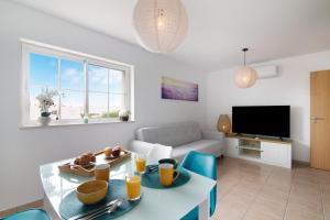 a living room with a table and a couch at Vista Mar in Cabanas de Tavira