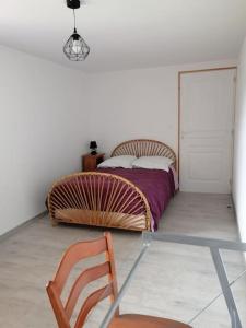 a bedroom with a bed and a chair in it at Maison de campagne in Saint-Jouan-de-lʼIsle