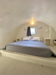 a bedroom with a large bed in an attic at The Muses of Santorini Private Jacuzzi Suites in Vóthon