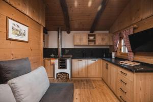 uma cozinha com armários de madeira e um sofá num quarto em Lechnerhütte Fane Alm em Valles