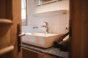 a white sink in a bathroom with a window at Lechnerhütte Fane Alm in Valles