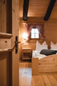 a wooden room with a bed and a window at Lechnerhütte Fane Alm in Valles