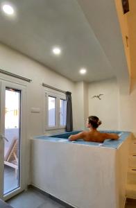 Ліжко або ліжка в номері The Muses of Santorini Private Jacuzzi Suites