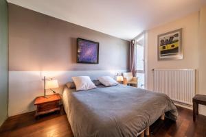 a bedroom with a bed and a lamp on a table at Gîte Le Jorat - Studio in Bogève