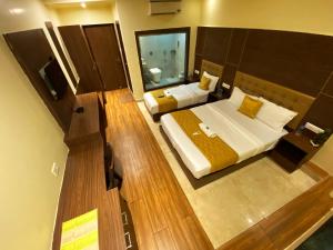 Hotel Pearl's BKC Inn- Near Trade Centre, Visa Consulate في مومباي: غرفة نوم كبيرة بسريرين ومرآة