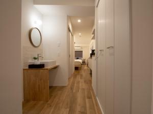 a hallway leading to a bathroom with a sink and a mirror at Tiz wan hotel in Sumoto +169 photos