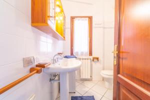 a white bathroom with a sink and a toilet at Myosotis Terrace by DomusAway in Porto San Paolo