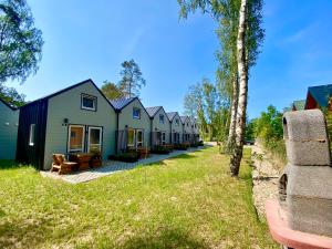 a row of houses in a row on a lawn at Domy nad morzem- Family Resort - Chata Pirata 2 in Dziwnów