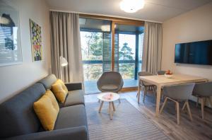 uma sala de estar com um sofá e uma mesa em Santa's Resort & Spa Hotel Sani em Kalajoki