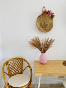 una mesa con una silla y un jarrón con flores en B&B L'albero di Melograno en Seccheto