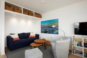 sala de estar con sofá azul y mesa en Dock19, en Heikendorf