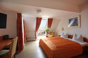 a hotel room with a bed and a desk and a window at Hotel Schiff am See in Konstanz